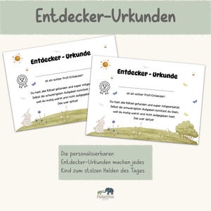 May include: Two certificates with the text "Entdecker-Urkunde" in German. The certificates have illustrations of a sun, a bunny, and a tree. The text on the certificates is in German.
