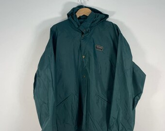 May include: A dark green hooded jacket with a snap closure and a small patch logo that reads "The North Face" on the left chest.