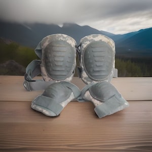 May include: A pair of gray and black knee pads with camouflage print. The knee pads have adjustable straps and are designed for protection.