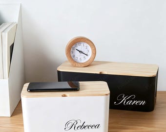 May include: A white rectangular storage box with the name Rebecca printed in black script and a black rectangular storage box with the name Karen printed in white script. Both boxes feature light wood lids and a small round wooden analog clock.