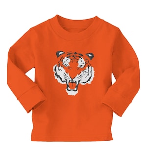 May include: Orange long-sleeved shirt with a black and white tiger face graphic.
