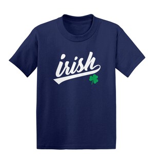 May include: A navy blue t-shirt with a white cursive word "irish" and a green four-leaf clover.
