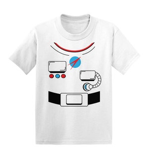 Puede incluir: Camiseta blanca con un diseño de traje de astronauta impreso. El diseño incluye un casco rojo y azul, un cinturón negro y un panel de pecho blanco con botones rojos, azules y blancos.