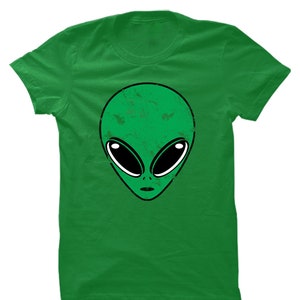 May include: Green t-shirt with a distressed alien face graphic.