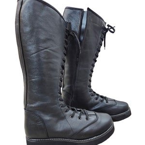May include: A pair of black leather wrestling boots with laces and a zipper on the side.