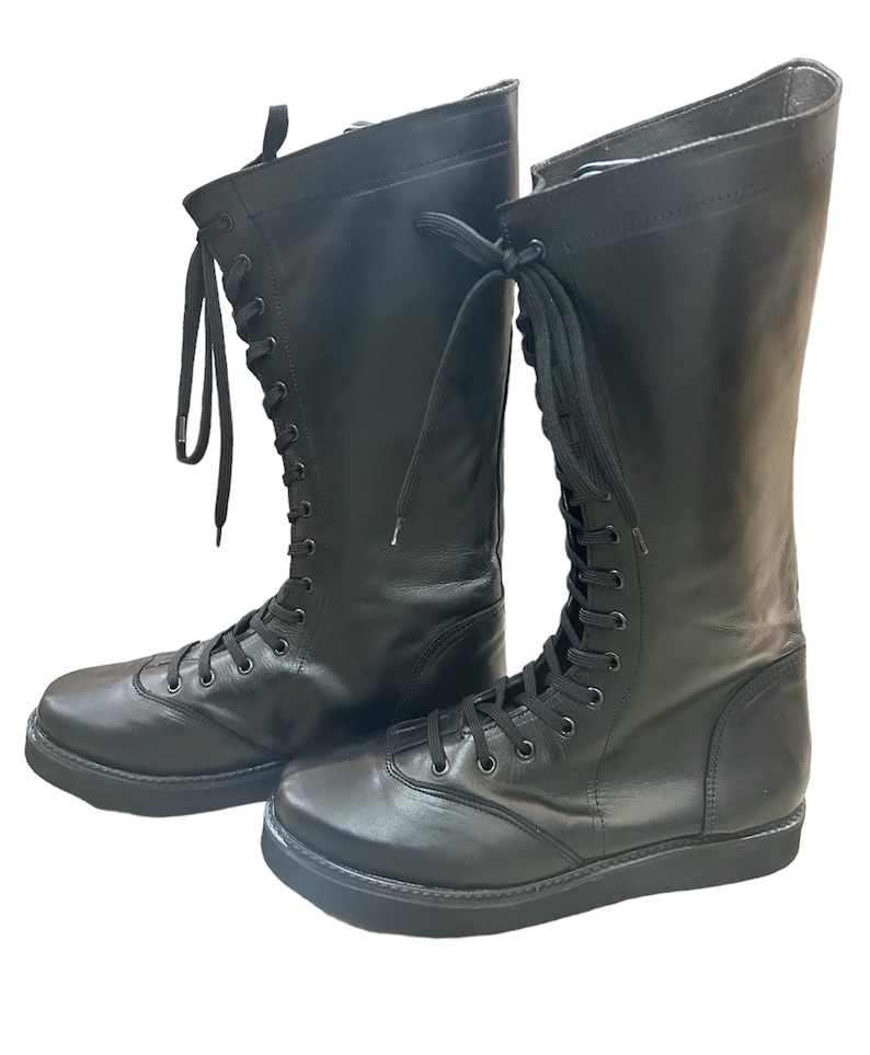 Puede incluir: Un par de botas negras de cuero con cordones y suela de plataforma gruesa.