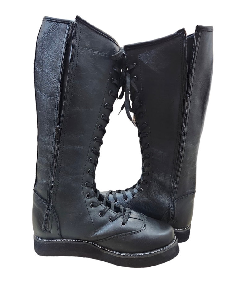 May include: A pair of black leather wrestling boots with laces up the front and a zipper on the side. The boots have a thick platform sole.