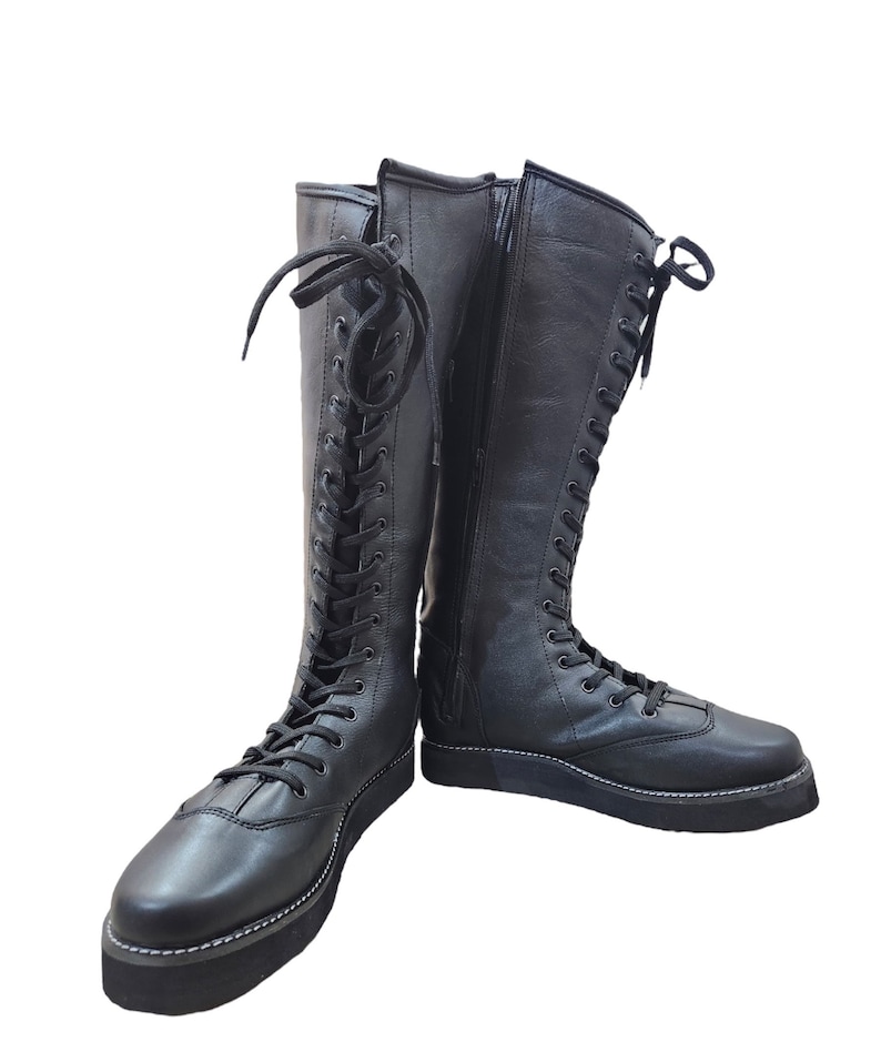 May include: A pair of black leather lace-up boots with a zipper on the side. The boots have a thick platform sole and are tied with black laces.