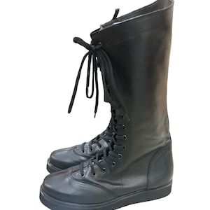 Puede incluir: Botas de cuero negro con cordones y suela gruesa.