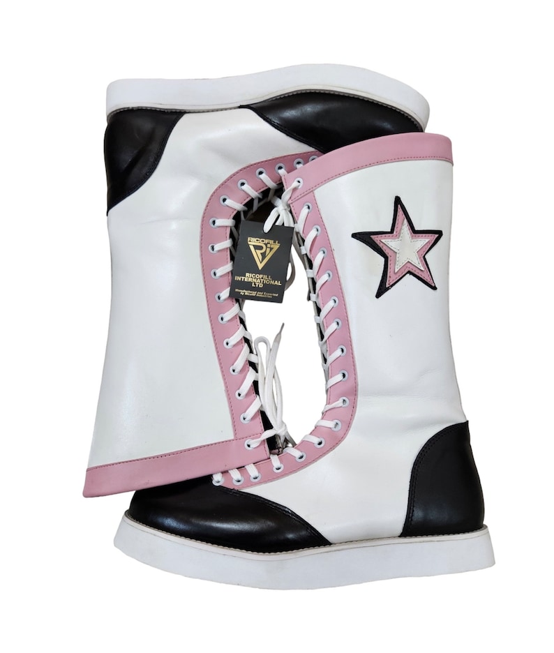 May include: White wrestling boots with black and pink accents. The boots have a star on the side and a label that says "Ricoff International Ltd."