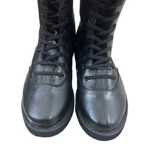 Puede incluir: Un par de botas negras de cuero con cordones y suela gruesa.