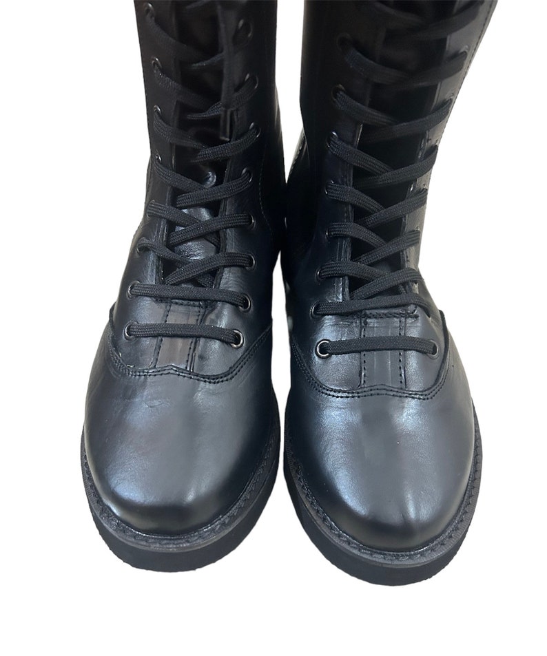 Puede incluir: Un par de botas negras de cuero con cordones y suela gruesa.