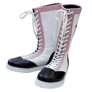 May include: A pair of white and black wrestling boots with pink accents and white laces.