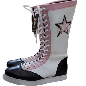 May include: White and black wrestling boots with pink accents and a white star on the side. The boots are laced up and have a white sole.