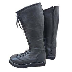 May include: A pair of black leather wrestling boots with laces up the front and a zipper on the back.