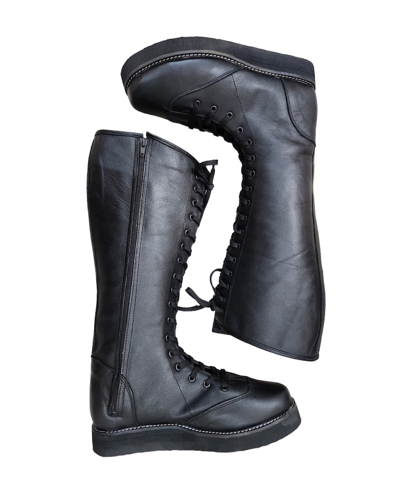 May include: Black leather knee-high boots with a lace-up front and a zipper on the side. The boots have a thick platform sole.
