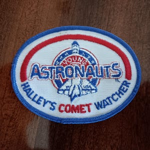 May include: A blue and red embroidered patch with the text "Young Astronauts Halley's Comet Watcher" and a space shuttle design.