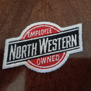 May include: White and red embroidered patch with the text "North Western Employee Owned".