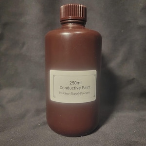 May include: A brown plastic bottle with a screw-top lid, featuring a white rectangular label that reads 250ml Conductive Paint Invictus-SupplyCo.com. The container is opaque and cylindrical, designed to hold liquid paint for electrical applications.