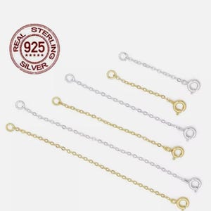 May include: An assortment of silver and gold-coloured chain extenders with lobster claw clasps and jump rings are shown. A circular stamp reads "REAL STERLING 925 SILVER" against a white backdrop.