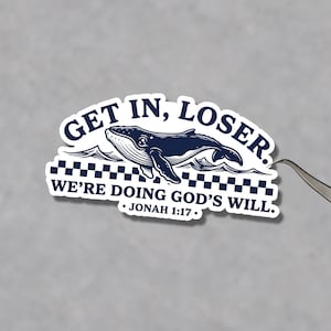 以下が含まれることがあります： クジラのイラストと「GET IN, LOSER. WE'RE DOING GOD'S WILL. JONAH 1:17」の文字が入った濃紺のステッカー。クジラは市松模様の上を泳いでいます。