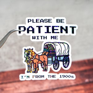 May include: A sticker with a glittery finish featuring a wagon pulled by two horses. The text on the sticker reads "Please be patient with me I'm from the 1900s".