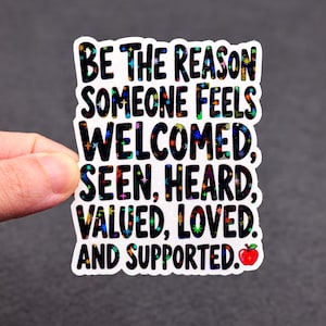 May include: A white sticker with the text "BE THE REASON SOMEONE FEELS WELCOMED, SEEN, HEARD, VALUED, LOVED, AND SUPPORTED." The text is in black with colorful star-shaped accents. A red apple graphic is in the bottom right corner.