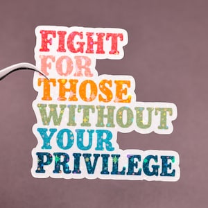 May include: A die-cut sticker featuring the text FIGHT FOR THOSE WITHOUT YOUR PRIVILEGE in a stacked, bold, sans-serif font. The letters have a holographic, star-patterned finish that shifts through red, orange, green, blue, and dark blue colors.
