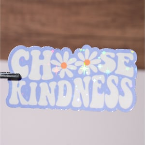 May include: A light blue sticker with the text "CHOOSE KINDNESS" in white, with two white daisies and glitter accents.