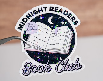 May include: A holographic sticker with a black background and a white open book with a purple bookmark. The sticker says "Midnight Readers Book Club" in a white cursive font with a crescent moon and stars. A small purple circle with the text "One more chapter" is in the top left corner.