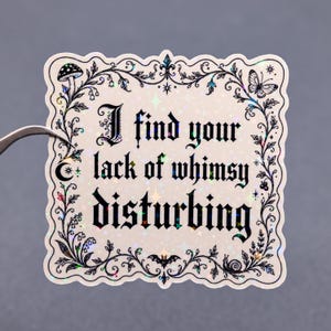 Puede incluir: Adhesivo cuadrado con el texto "I find your lack of whimsy disturbing" en fuente g&oacute;tica. El adhesivo tiene un borde negro decorativo con ilustraciones de setas, mariposas y murci&eacute;lagos. Acabado hologr&aacute;fico iridiscente.