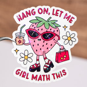 May include: A pink strawberry cartoon character wearing sunglasses, holding a glass of iced tea and a red shopping bag with two stars. The text reads "Hang on, let me girl math this".