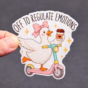May include: A sticker featuring a cartoon duck riding a pink scooter and holding a coffee cup. The duck has a pink bow and the text "OFF TO REGULATE EMOTIONS" is above it. The sticker has a glittery, holographic effect.