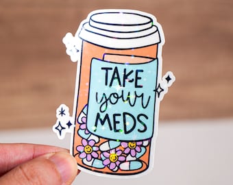 May include: A holographic sticker of a pill bottle with a blue label that says "Take your meds". The bottle is filled with colorful pills and flowers.