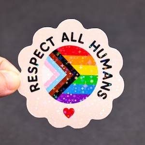 May include: A scalloped-edge sticker with a holographic finish featuring the text RESPECT ALL HUMANS in black. The center displays a progress pride flag with rainbow stripes and a chevron pattern, accented by a small red heart at the bottom.