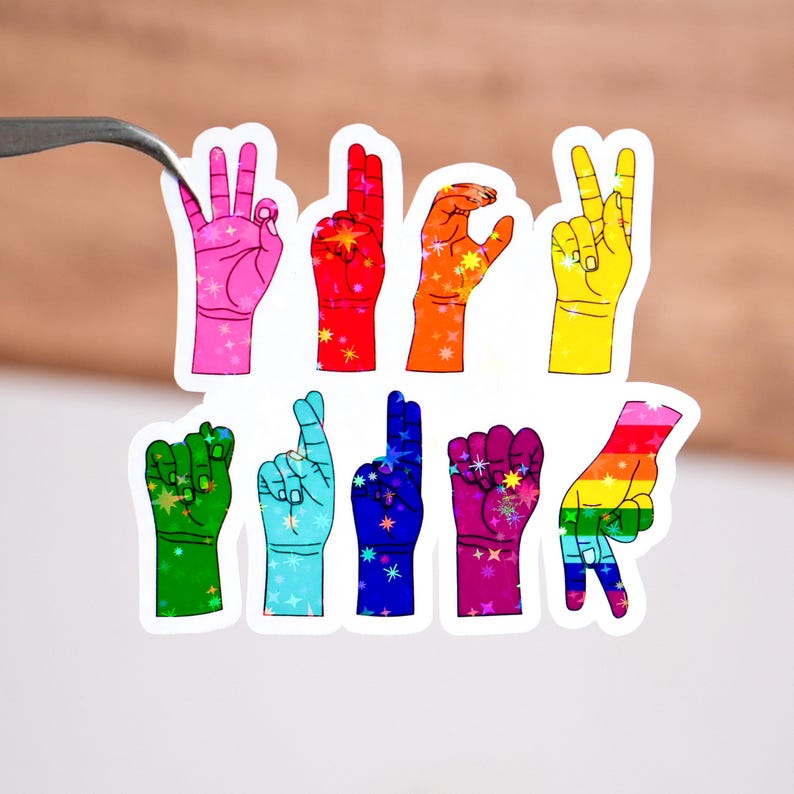 May include: A set of eight rainbow colored hand stickers featuring the American Sign Language alphabet. The stickers are on a white background.