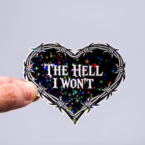 Op de afbeelding: Een hartvormige sticker met een zwarte achtergrond vol kleurrijke sterren. De sticker is omrand met prikkeldraad en heeft de tekst "THE HELL I WON'T" in het wit. De sticker wordt door een hand vastgehouden.