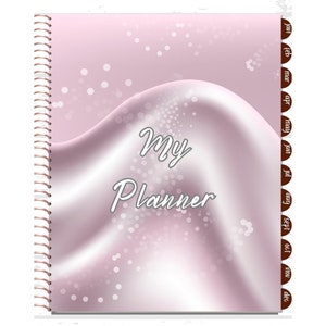 Op de afbeelding: Een roze planner met een wit en roze swirl-ontwerp en de tekst "My Planner". De planner heeft een spiraalbinding en maandelijkse tabs.