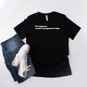 May include: Black t-shirt with white text that reads "life happens. wealth management helps."
