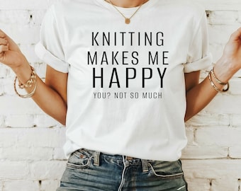 May include: White t-shirt with black text that reads "Knitting makes me happy. You? Not so much."