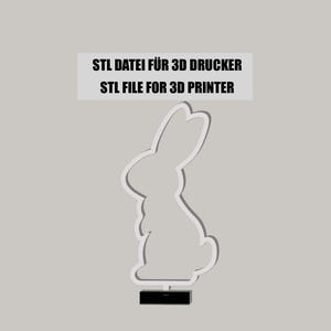 Könnte beinhalten: Ein weißes 3D-druckbares Modell eines Kaninchens, das auf einem schwarzen Sockel steht. Der Text "STL FILE FOR 3D PRINTER" und "STL DATEI FÜR 3D DRUCKER" wird über dem Kaninchen angezeigt.