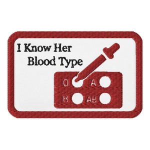 May include: Embroidered patch with a white background and a red border. The text "I Know Her Blood Type" is above a blood typing graphic with a dropper. The blood types O, A, B, and AB are displayed.