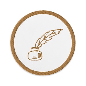 May include: A brown embroidered patch with a white background featuring a quill pen and inkwell.