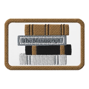 May include: Embroidered patch featuring a stack of books. The top book is brown, the middle book is black, and the bottom book is silver. A silver banner across the middle book reads "The Manuscript". The patch has a brown border.