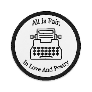 Puede incluir: Un parche redondo blanco con un borde negro que presenta un dibujo lineal negro de una máquina de escribir. El texto "All Is Fair, In Love And Poetry" está bordado en negro.