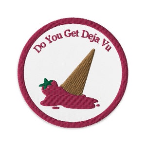 May include: Embroidered patch with a white background and a maroon border. The patch features a brown ice cream cone tipped over, with a red, melted ice cream design. The text "Do You Get Deja Vu" is embroidered in maroon.