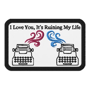 Puede incluir: Parche bordado con el texto "I Love You, It's Ruining My Life". Presenta dos máquinas de escribir antiguas con diseños estilizados en forma de humo rojo y azul. El parche tiene un borde negro.