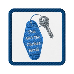 May include: Blue and white embroidered patch with a motel key tag that says "This Ain't The Chelsea Hotel".