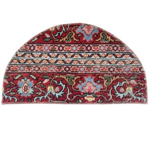 May include: A half-circle rug with a traditional design. The rug features a red background with floral and geometric patterns in shades of blue, pink, and green. The rug's border has a light blue and pink stripe.