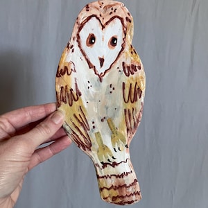 May include: A white ceramic mug with a black handle and the text "But First, Coffee" in a black, bold font. The mug is on a white surface. The mug is approximately 4 inches tall.